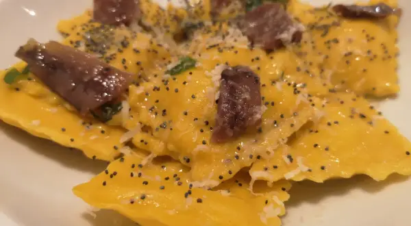 Ravioli gialli con acciughe e semi di papavero, un piatto da provare alla trattoria da me Bologna.