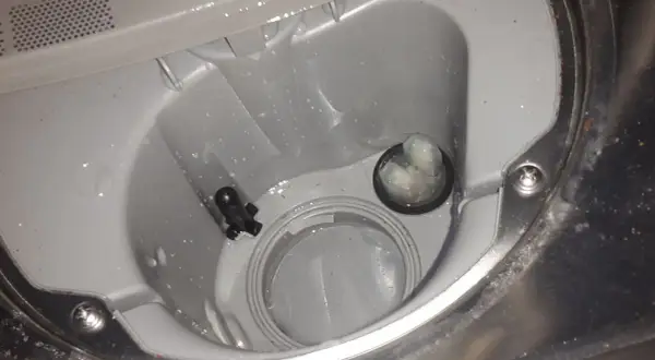 Wnętrze zmywarki Beko z błędem E01. Widoczny filtr i czujnik poziomu wody.