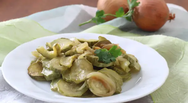 Zucchine in padella con cipolla, un contorno semplice e gustoso, guarnito con prezzemolo fresco.