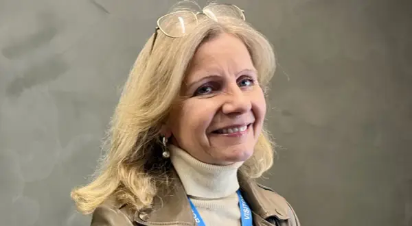 Helene Barnekow ler mot kameran, med glasögon på huvudet och en beige polotröja under en brun jacka.