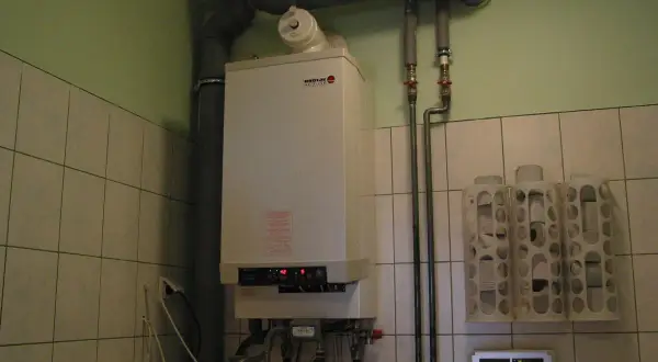 Kocioł gazowy Broetje, który pokazuje, jak ogrzewane są bloki. Obok wiszą uchwyty na papier toaletowy.