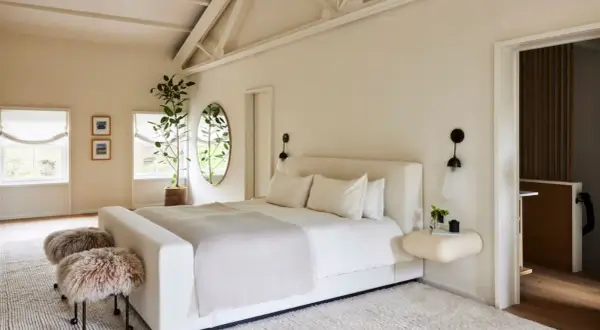 Serene bedroom with a large bed, fluffy stools, and a plant, creating positive energy placement feng shui bedroom vibes.
