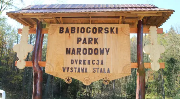 Drewniana tablica informacyjna Babiogórskiego Parku Narodowego. Zapowiada liczne zawoja atrakcje i wystawę stałą.