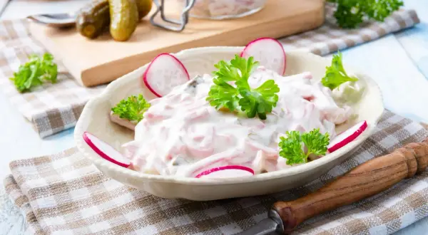 Leckerer Fleischsalat, garniert mit Radieschen und Petersilie. Ein einfaches Rezept für den perfekten Fleischsalat.