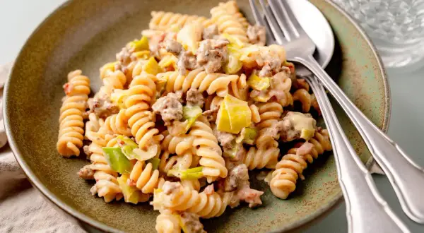 Herzhafte Hackfleisch Lauch Pfanne mit Spiralnudeln, cremig und appetitlich auf einem rustikalen Teller angerichtet.