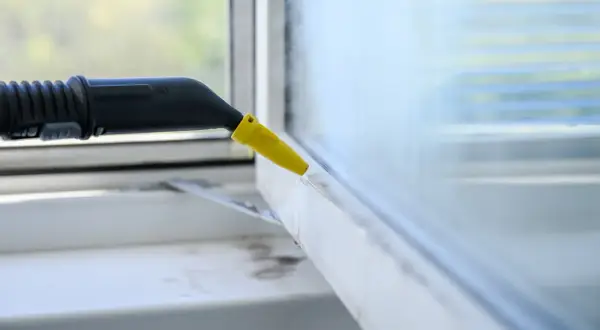 Czyszczenie ram okiennych parownicą, która skutecznie usuwa brud, jakby używano sody.