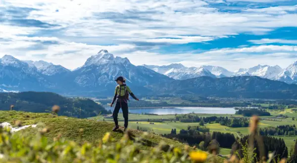 Wanderin genießt Ausblick auf Alpenpanorama, ein perfekter Moment auf den Fernwanderwegen Alpen.