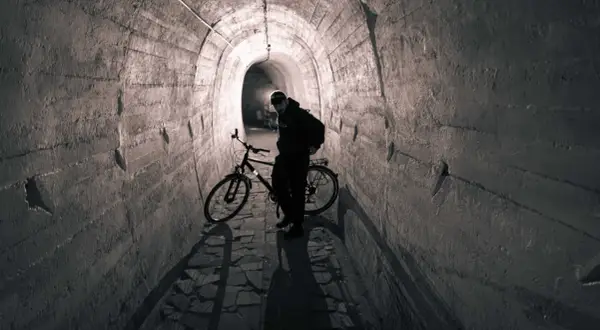 Mężczyzna z rowerem w tunelu. To może być początek jego przygody na podziemnej trasie rowerowej.