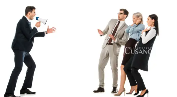 Uomo con megafono urla a tre persone spaventate. Impara a farsi rispettare da un uomo con assertività.