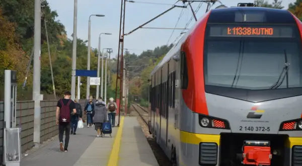 Pociąg Łódzkiej Kolei Aglomeracyjnej z numerem 11338 do Kutna stoi na peronie. Ludzie czekają na podróż.