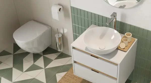 Nowoczesna łazienka z białym, wiszącym wc w rogu, umywalką nablatową i zielonymi płytkami.