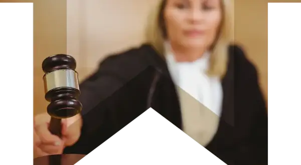 Sędzia z młotkiem w dłoni, symbol sprawiedliwości i ochrony skarb państwa.