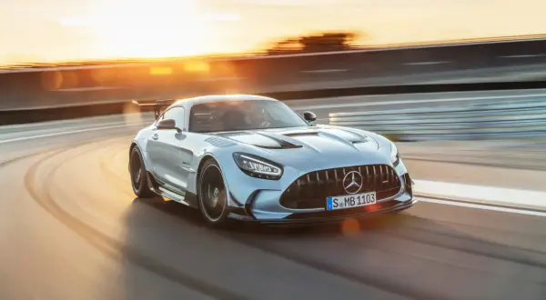 Srebrny Mercedes-AMG GT Black Series na torze wyścigowym, w promieniach zachodzącego słońca.