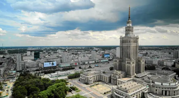 Warszawski Pałac Kultury i Nauki góruje nad miastem, ukazując swoją imponującą wysokość na tle chmur.