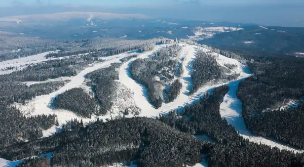 Schneebedeckte Hänge und Wälder, perfekt für einen Tag auf dem Plesivec Ski.