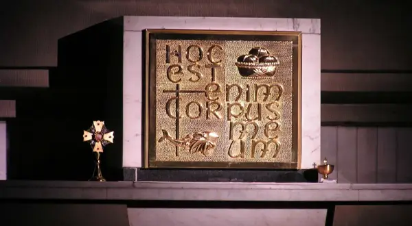 Złote tabernakulum z napisem "Hoc est enim corpus meum" i symbolem ryby. Obok krzyż relikwiarzowy.