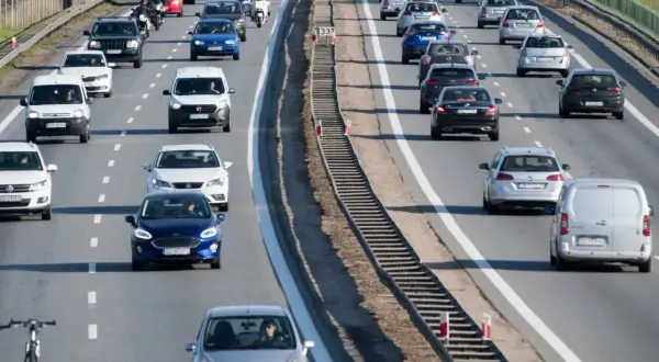 Ruch na drodze dwujezdniowej. Samochody osobowe i dostawcze jadą w korku.