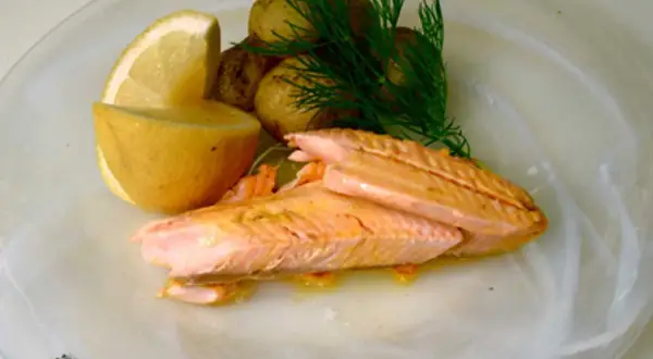 Hel regnbåge i ugn, serverad med småpotatis, citron och dill. En vacker och smakrik rätt.