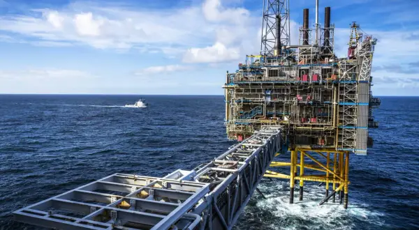 Ölplattform im Meer, die den Reichtum des norwegischen Staatsfonds repräsentiert. Ein Versorgungsschiff fährt vorbei.