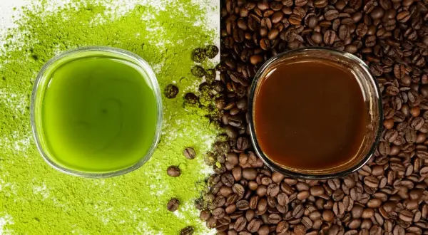 Zielony napój matcha obok ciemnej kawy, otoczone proszkiem matcha i ziarnami kawy. Wybór na poranek: matcha zamiast kawy?