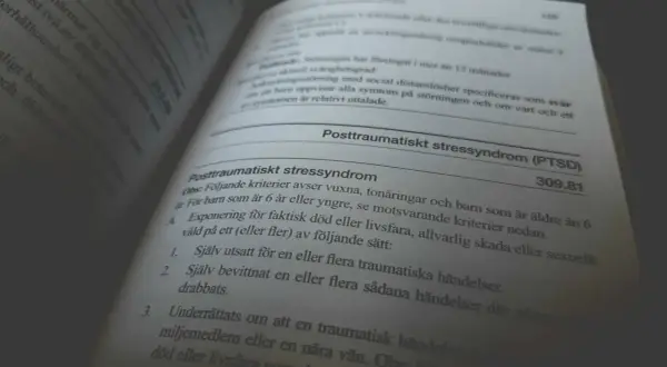 En boktext beskriver kriterier för posttraumatiskt stressyndrom (PTSD) och dess konsekvenser.