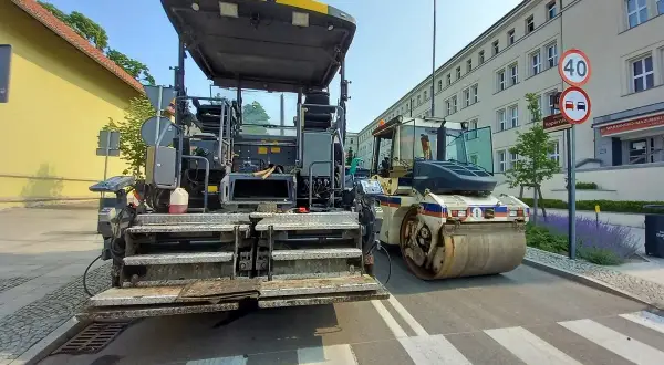 Asfaltarka i walec drogowy na pasach dla pieszych w Olsztynie.
