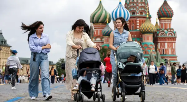 Kobiety z wózkami spacerują po Placu Czerwonym. Tłum ludzi, jak na obrazku, to tylko ułamek całej **rosja liczba ludności**.