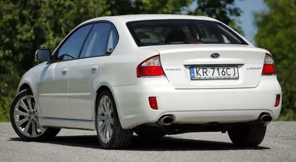 Biały Subaru Legacy z tablicą KR 716CJ.