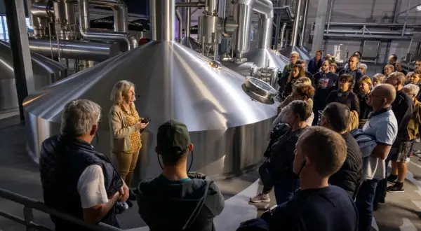 Visite Goudale : un groupe découvre les cuves de brassage. Une guide explique le processus de fabrication de la bière.