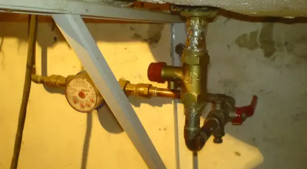 Zawór bezpieczeństwa w bojlerze, obok wodomierza, zapewnia ochronę instalacji.