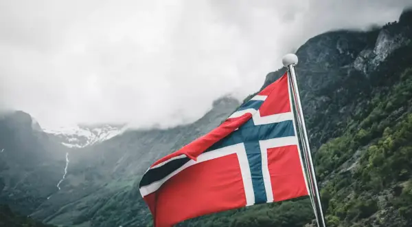 Norwegia: malownicze fiordy i wysokie norwegia zarobki netto. Flaga powiewa na maszcie, zapraszając do odkrywania piękna i możliwości.