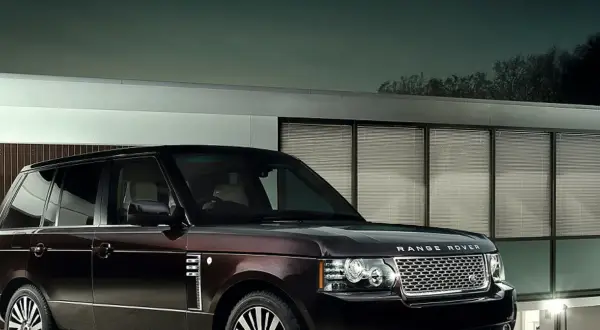Elegancki Range Rover Autobiography w ciemnym kolorze lśni przed nowoczesnym budynkiem z przeszklonymi oknami.