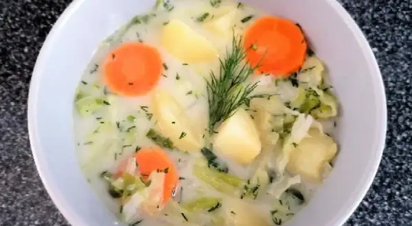 Aksamitna zupa z białej kapusty z ziemniakami i marchewką, ozdobiona koperkiem. Pyszne, domowe danie.