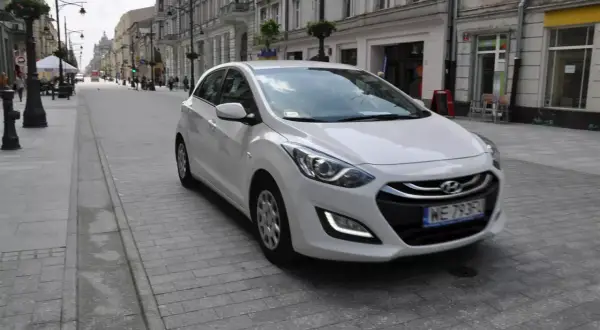 Biały Hyundai i30 1.4 benzyna na brukowanej ulicy w mieście.