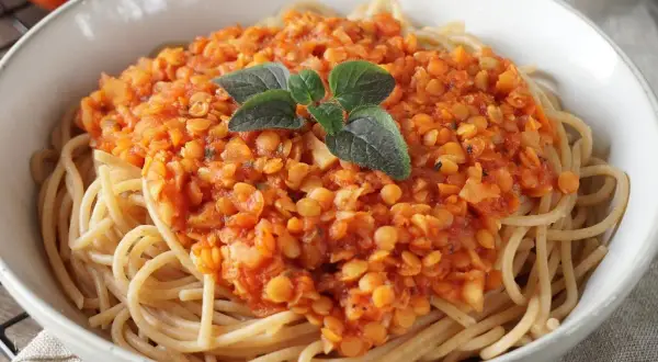 Herzhafte Linsen Bolognese auf Spaghetti, garniert mit frischen Kräutern. Ein köstliches vegetarisches Gericht.