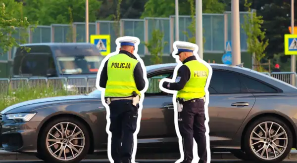 Policjanci kontrolują kierowcę, który prawdopodobnie otrzyma mandat za jazdę z hakiem.