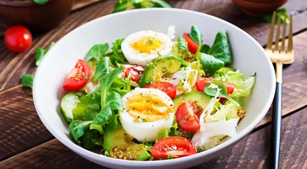 Frischer Salat mit Avocado, Tomaten und gekochten Eiern – perfekt für eine leichte Mahlzeit zum Abnehmen.