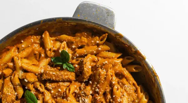 En krämig pasta i ugn med kyckling och en smakrik tomatsås, toppad med färsk basilika och parmesan.