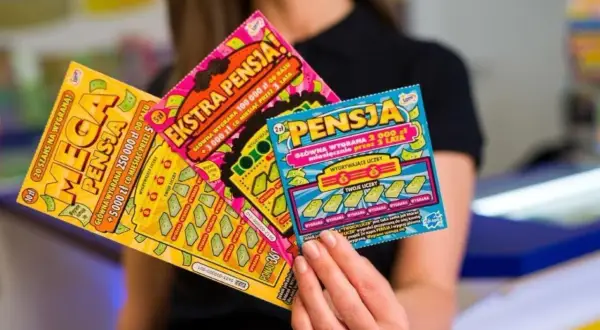 Kobieta trzyma zdrapki lotto: "Mega Pensja", "Ekstra Pensja" i "Pensja". Sprawdź zasady gry, by wygrać ekstra pensję!