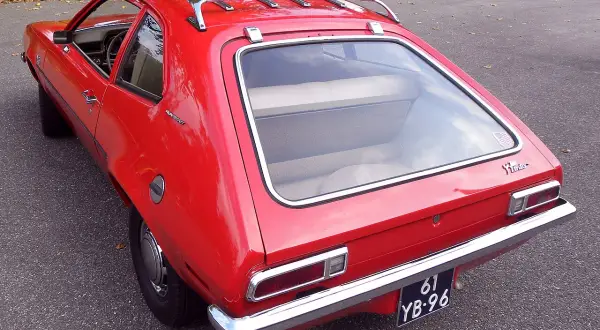 Czerwony Ford Pinto Runabout z bagażnikiem dachowym, gotowy na przygodę.