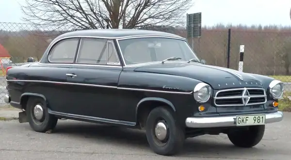 Svart Borgward Isabella, en klassisk bil med kromdetaljer, står parkerad utomhus.