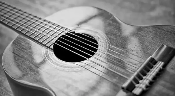 Zbliżenie na gitarę klasyczną. Zastanawiasz się, ile kosztuje dobra gitara? Ten instrument wygląda na wart swojej ceny.