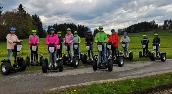 Eine Gruppe von Menschen steht auf Segways, die eine einfache Art der Fortbewegung darstellen.