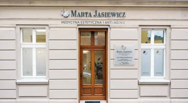 Elegancka fasada kliniki medycyny estetycznej Marta Jasiewicz z drewnianymi drzwiami i oknami.