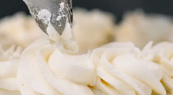 Dekorowanie tortu kremem patissiere za pomocą rękawa cukierniczego.