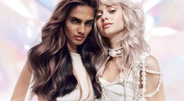 Deux femmes aux cheveux magnifiques, l'une brune avec des reflets, l'autre blonde platine. Le shampoing après patine Dialight sublime leurs couleurs.