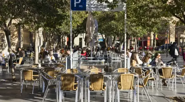 Gente disfrutando en las terrazas de la Plaza San Francisco Zaragoza, bajo la sombra de los árboles.