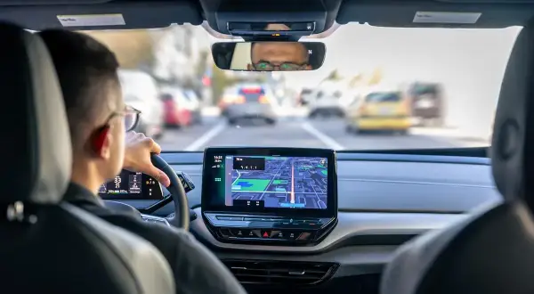 Conducteur concentré sur le GPS, préparant sa lettre de motivation pour devenir conducteur de voiture radar.