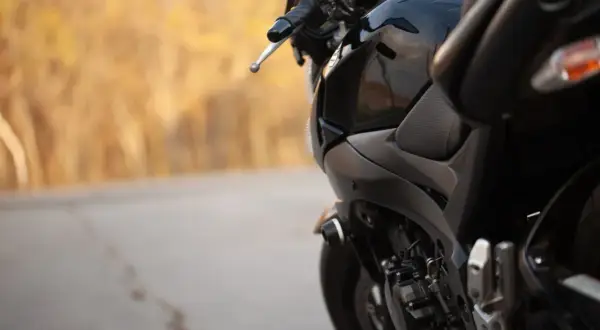 Czarny motocykl na tle jesiennego krajobrazu. Zastanawiasz się, jaki przebieg dla motocykla jest duży? Ten wygląda na gotowy na wiele przygód.