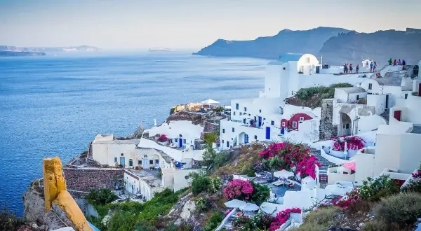Malownicze białe domy na Santorini, kwitnące bugenwille i błękitne morze. Czy do Grecji potrzebny jest paszport? Tak, jeśli nie jesteś obywatelem UE.
